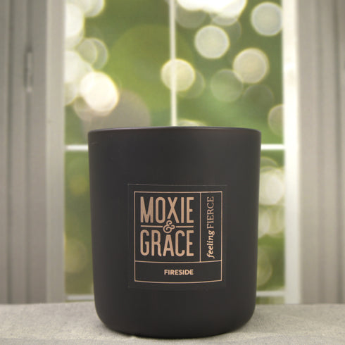 Fireside 12oz Candle in Black by Moxie & Grace — a warm, smoky blend of cedarwood, sandalwood, birch, and smoked amber