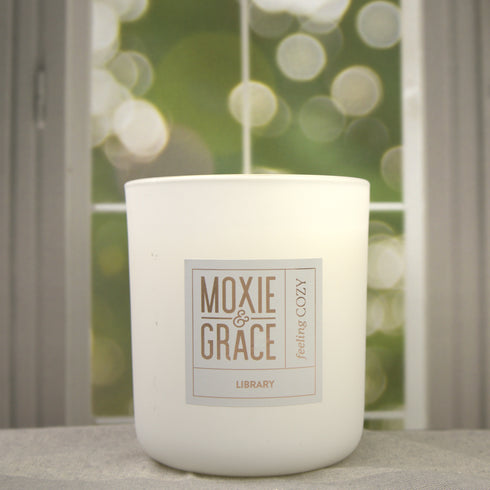 Library 12oz Candle in White by Moxie & Grace — a sophisticated blend of teakwood, cedar, leather, sandalwood, and dark musk