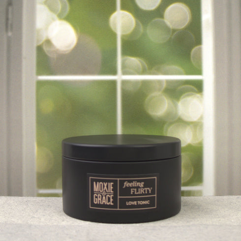 Love Tonic 5oz Candle in Black by Moxie & Grace — a sweet fruity-floral blend of apple, peach, cherry blossom, hydrangea, and vanilla
