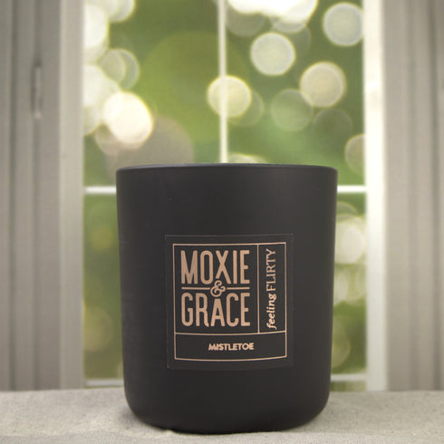 Mistletoe 12oz Candle in Black by Moxie & Grace — a festive blend of pine, peppermint, eucalyptus, and fresh winter greens