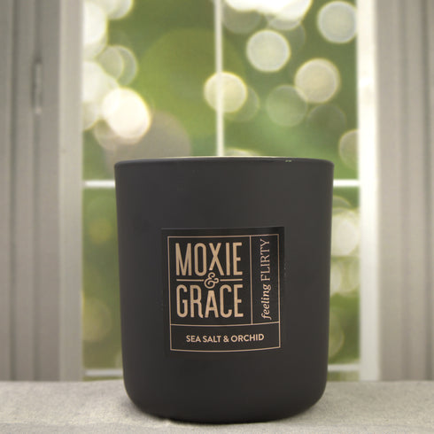 Sea Salt & Orchid 12oz Candle in Black by Moxie & Grace — a coastal floral blend of sea salt, freesia, orchid, tonka bean, and amber