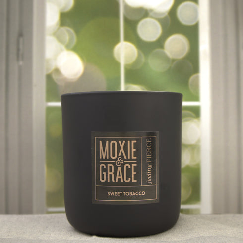 Sweet Tobacco 12oz Candle in Black by Moxie & Grace — a rich, warm blend of tobacco, vanilla, honey, amber, and dark musk