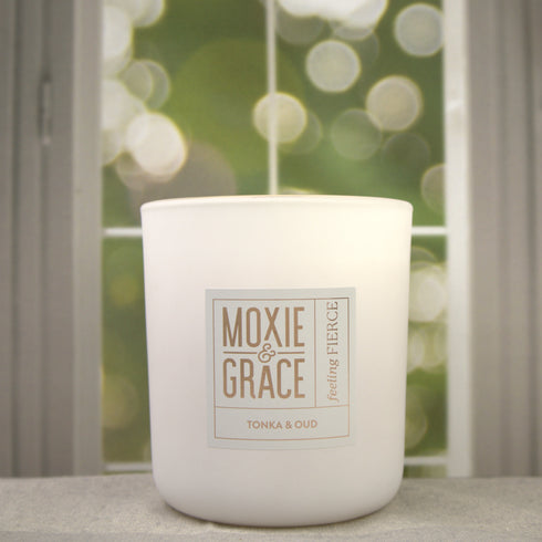 Tonka & Oud 12oz Candle in White by Moxie & Grace — a luxurious blend of oud, tonka bean, sandalwood, amber, and dark musk