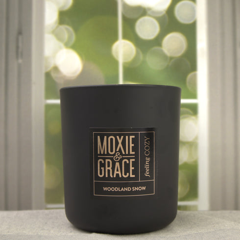 Woodland Snow 12oz Candle in Black by Moxie & Grace — a crisp, wintry blend of pine, cedarwood, eucalyptus, and fresh snow