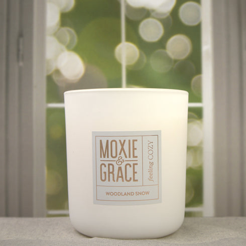 Woodland Snow 12oz Candle in White by Moxie & Grace — a crisp, wintry blend of pine, cedarwood, eucalyptus, and fresh snow